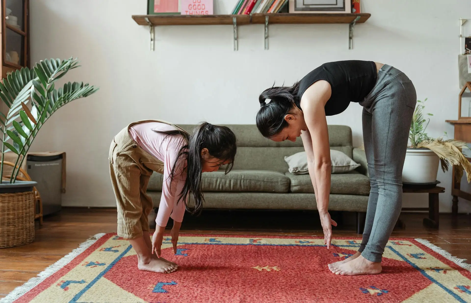 A small girl and an women is exercising together