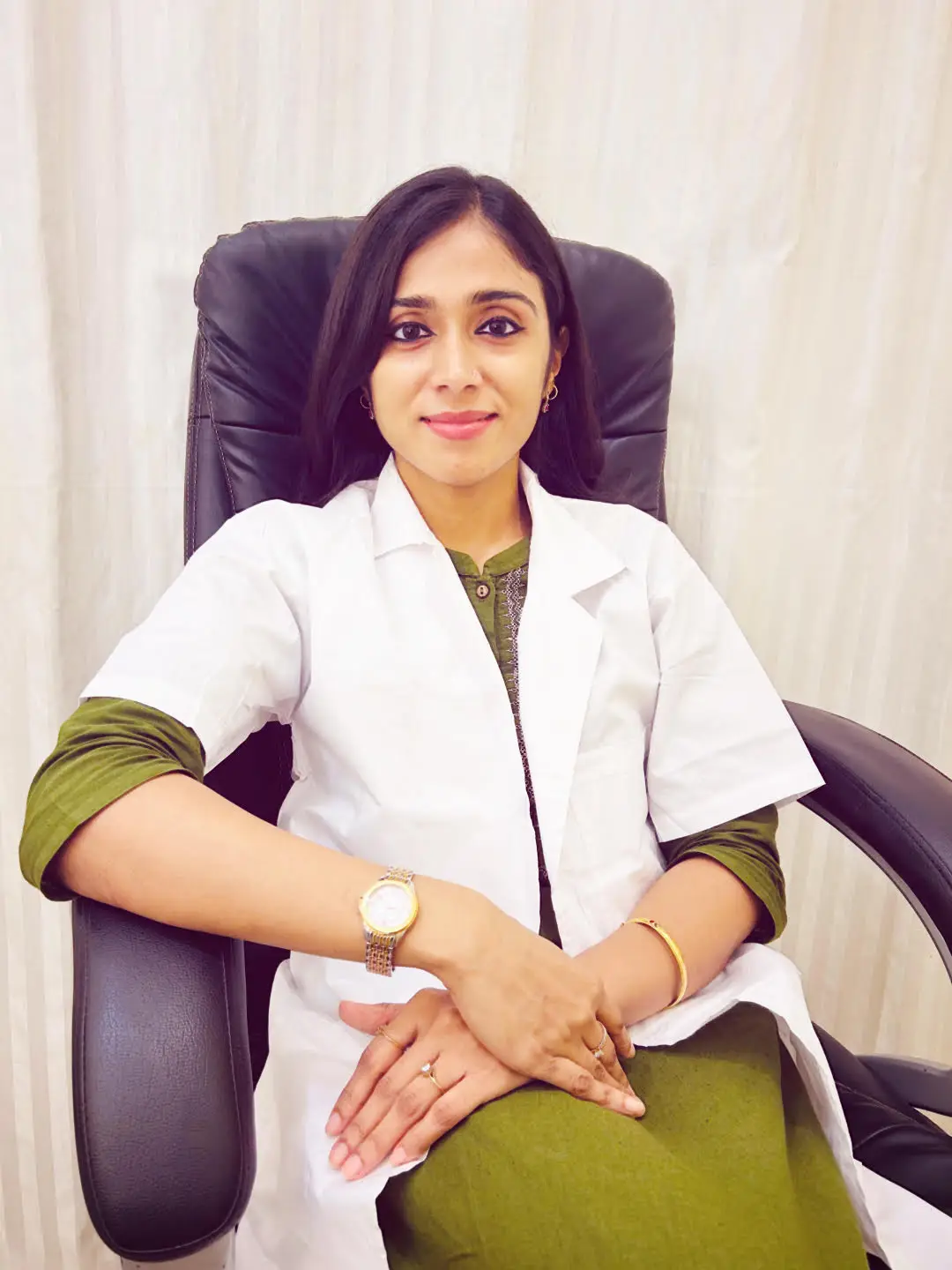 Dr. Devika De Ghosh Sitting on a Chair & Smiling